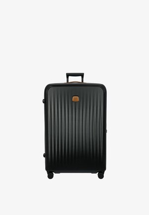 Maleta dura negra con textura de surcos verticales, detalles en cuero color crema, asa en la parte superior y cuatro ruedas para una fácil movilidad.