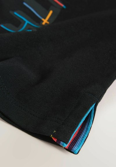 Manchon en tissu noir avec une doublure intérieure rayée colorée en bleu, rouge et violet, avec un petit détail d'ouverture latérale.