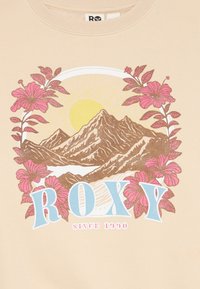Paesaggio montano con un sole giallo, circondato da fiori rosa e testo blu "ROXY" con "Dal 1990" in basso su tessuto beige.