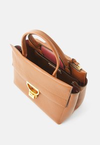 Sac à main en cuir tan au design structuré, doté de deux poignées et d'un fermoir en métal doré. À l'intérieur, il y a des compartiments avec des doublures sombres.