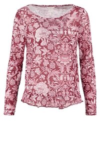 Chemise rouge à manches longues avec un motif floral blanc complexe et un ourlet froufroutant en bas.