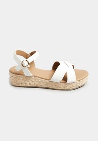 Sandali wedge bianchi con design a fasce incrociate, cinturino alla caviglia regolabile e tacco in juta intrecciata. Materiale in finta pelle liscia e suola beige.