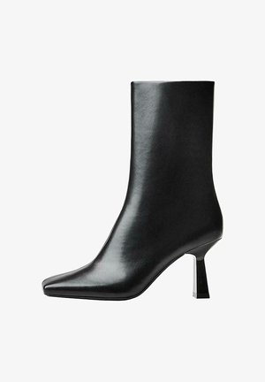 Stivale alla caviglia in pelle nera con punta affusolata e tacco a blocco elegante. Texture liscia con una silhouette moderna e slanciata.