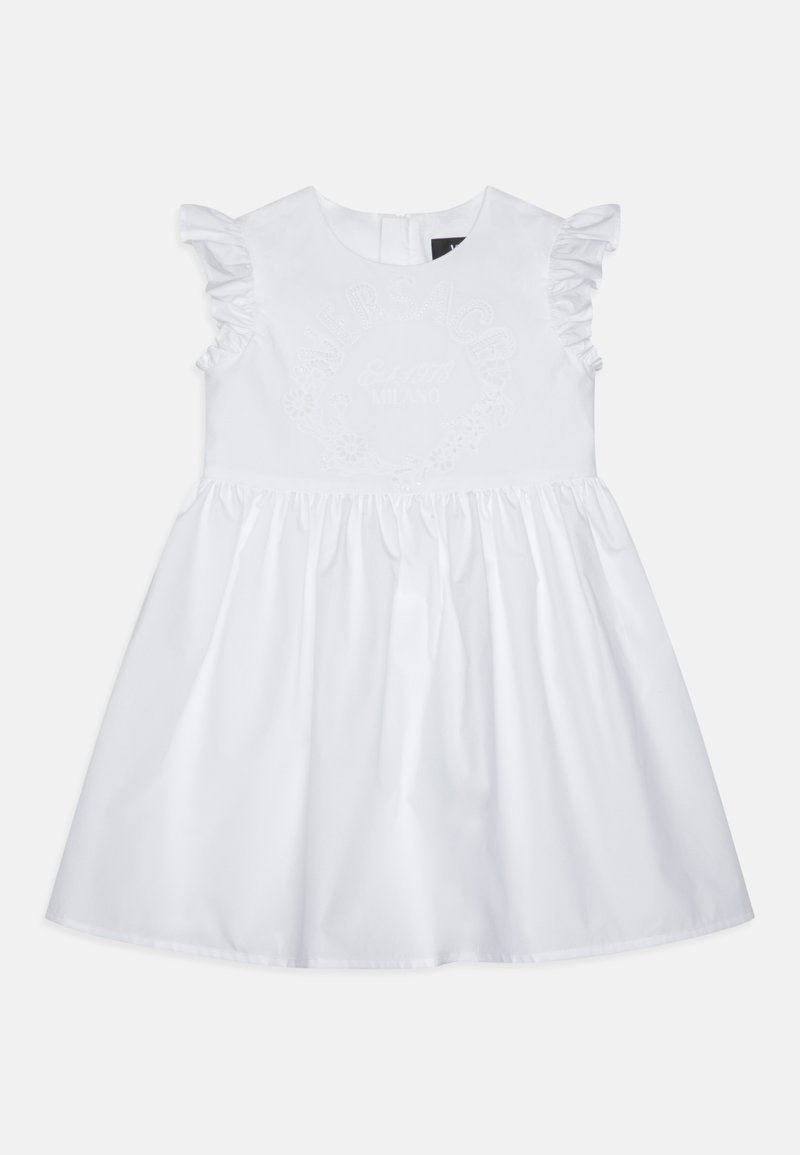 Balta kleita ar volāniem uz piedurknēm, izšūts zīmola nosaukums un gads, izvērsta svārku daļa, izgatavota no viegla auduma ar gludu tekstūru.