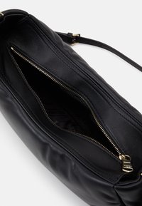 Borsa a spalla in pelle nera con una texture liscia, dotata di una cerniera dorata e di una singola tracolla regolabile. Dettagli cuciti lungo i bordi.