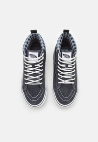 Höga sneakers i mörkblå mocka med vita snören. Insidan har ett blått och svart rutmönster. Vit gummisula.