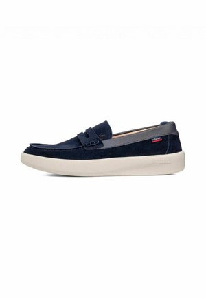 Mocassino in camoscio blu navy con rifinitura grigia e suola bianca, con cinturino cucito e piccola etichetta del marchio rossa e blu sul lato.