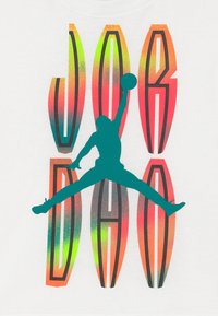 Musta T-paita, jossa on suuri, monivärinen grafiikka hyppivästä siluetista ja rohkeat kirjaimet "JORDAN" vaihtelevissa oranssin ja vihreän sävyissä.