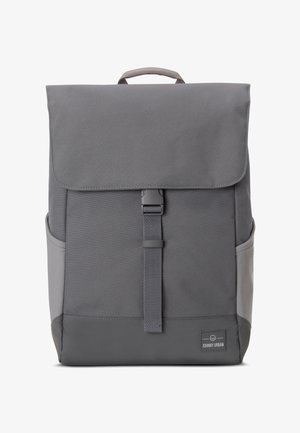 Rucsac din material textil gri, cu închidere tip clapetă, cataramă frontală, buzunare laterale și finisaj texturat. Placă cu logo pe partea inferioară frontală.