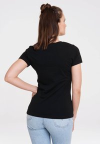 Black short-sleeve t-shirt made of cotton, featuring a classic fit, round neckline, and smooth texture, paired with light blue jeans.
