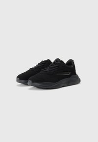 Black athletic sneakers made of suede and mesh, featuring textured rubber soles, round toe design, and subtle side accents.