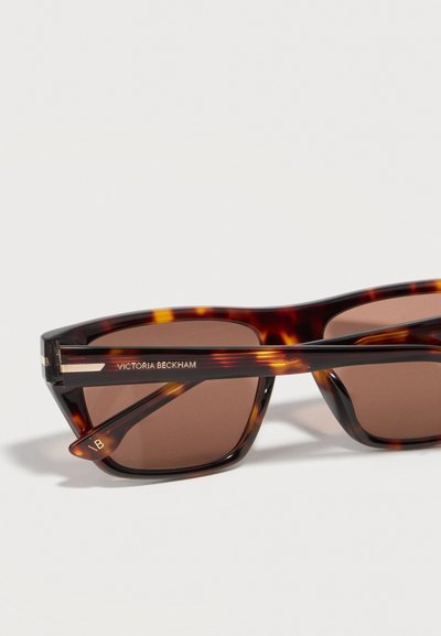 Ορθογώνια γυαλιά ηλίου από χελώνα με καφέ φακούς, με την ένδειξη "Victoria Beckham" στο σκελετό και χρυσές λεπτομέρειες.