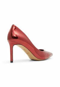 Červená lakovaná kožená vysoká bota s špičatou špičkou, štíhlým stiletto podpatkem a výřezovým designem na svršku. Zlaté logo na stélce.