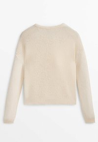 Pull en maille couleur crème avec manches longues, poignets, ourlet et col ras du cou côtelés, vu de dos.