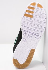 Czarne sneakersy z teksturowanym wierzchem, z białą gumową podeszwą i sekcją z gumy. Wyraziste akcenty w miętowej zieleni po boku.