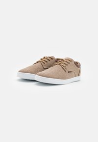 Brown fabric sneakers with white rubber soles, featuring round laces, a smooth back accent, and a streamlined design.