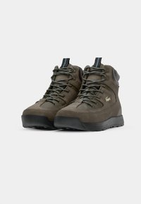 Brown suede high-top shoes with mesh panels, reinforced toe, and blue accents on laces. Textured surface and black rubber sole.