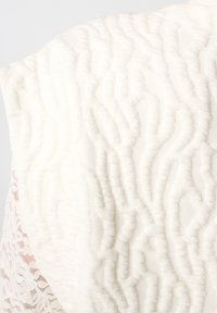 Gestructureerde witte stof met een golvend patroon, bestaande uit gladde en kantachtige materialen voor een gelaagd effect.