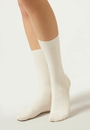 Knielange, gerippte Socken in Creme, aus einer weichen, dehnbaren Baumwollmischung mit einem verstärkten Bündchen und nahtloser Zehenpartie für zusätzlichen Komfort.