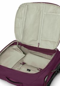 Maleta rodante morada con un interior beige, que cuenta con bolsillos de malla, múltiples compartimentos y cremalleras duraderas.