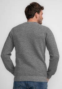 Grauer, gestrickter Pullover mit einem strukturierten Muster, Rundhalsausschnitt und langen Ärmeln. Der untere Saum und die Bündchen sind gerippt für einen engen Sitz.