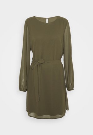 Pitkähihainen oliivinvihreä mekko, jossa on pyöreä pääntie, vyötärönauhalla solmittava rusettikoriste ja hieman läpikuultava kangas hihoissa ja helmassa.