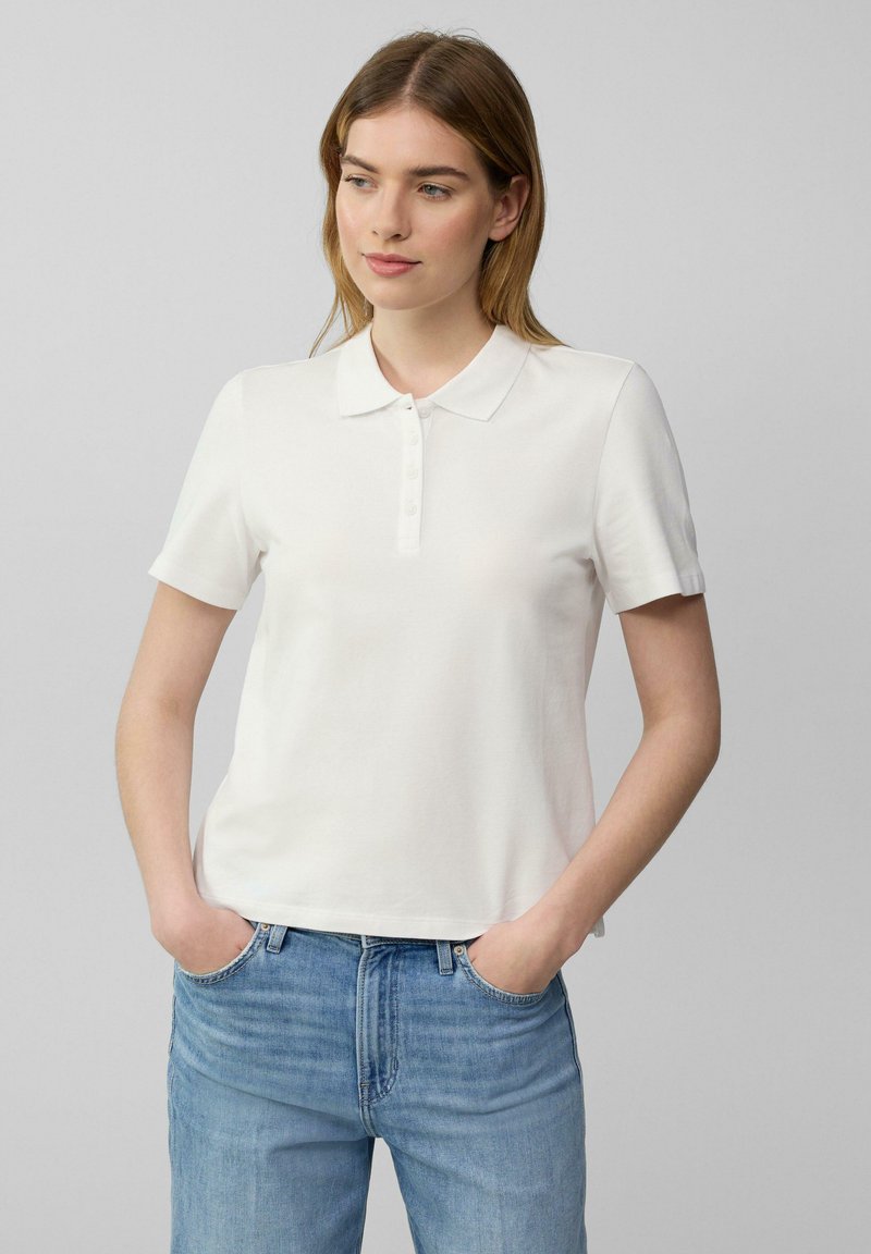 Witte polo shirt gemaakt van zachte katoen, met een klassieke kraag en korte mouwen, voorzien van een knoopsluiting en een relaxte pasvorm.