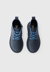 Stivaletti alla caviglia in pelle navy con lacci blu, punta rotonda, colletto imbottito e suola in gomma texture. Presentano una cerniera laterale per un facile accesso.