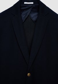 Marineblauer Blazer aus strukturiertem Stoff, mit klassischem Revers, einzelner goldener Knopfleiste und glattem Innenfutter.