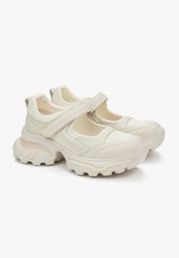 Witte mesh en synthetische schoenen met een klittenbandsluiting en een chunky rubberen zool met een gestructureerd ontwerp en een ronde neus.