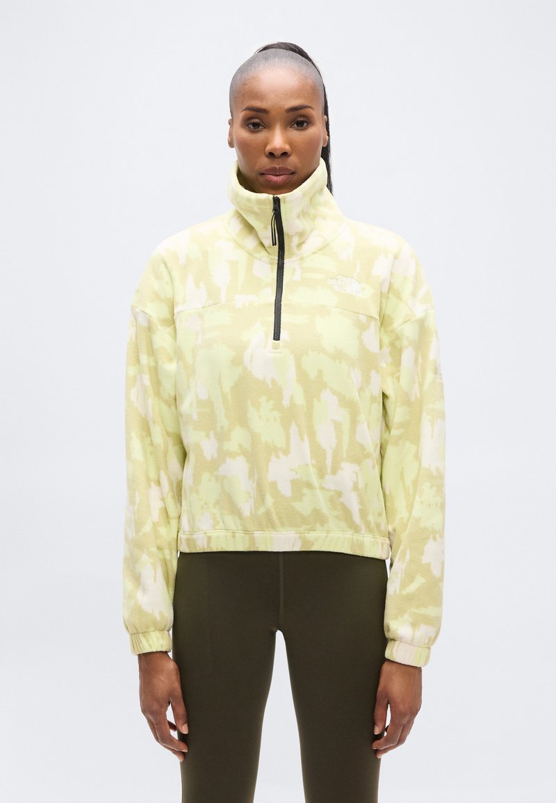 Φλις πουλόβερ σε ανοιχτό πράσινο με αφηρημένα λευκά σχέδια, φερμουάρ στον λαιμό, ψηλό γιακά και ελαστικά μανσέτες. Σχεδιασμένο για άνεση και ζεστασιά.