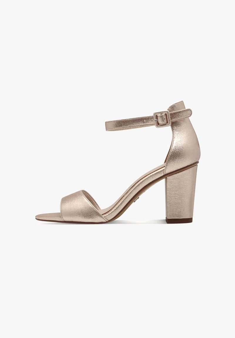 Sandale à talon ouverte en rose gold métallisé avec un talon épais et une bride de cheville, offrant une texture lisse et un design minimaliste.