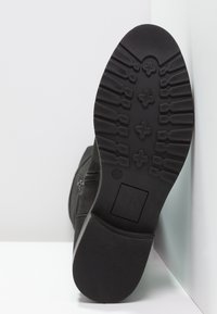 Černý semišový kotníkový boot s texturovanou gumovou podrážkou. Obsahuje boční zip a hladký, plochý podpatek, velikost označena jako 37.