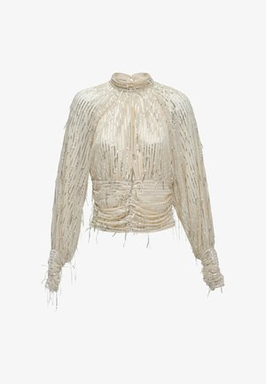 Blusa beige transparente con mangas largas, cuello alto, cintura fruncida y adornos de lentejuelas plateadas verticales por toda la prenda.