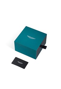 Teal karp, millemu sulgemisega, mille peal on hõbedane tiiva logo ja must kaart kõrval. Sujuv mati viimistlusega.