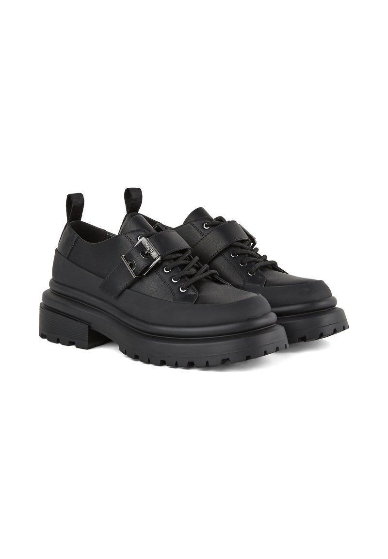 Chaussures en cuir noir avec une semelle épaisse, dotées d'une sangle avec une boucle, design à lacets et accents texturés autour de la tige.