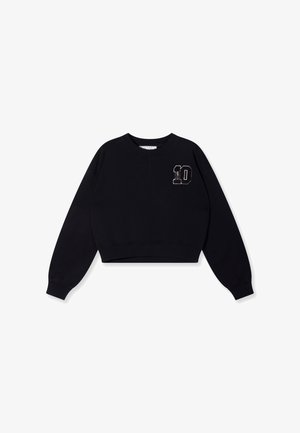 Zwarte cropped sweatshirt van zachte stof. Voorzien van lange mouwen, een ronde halslijn en een witte geborduurde "10" op de borst.