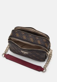 Borsa a tracolla marrone con motivo e loghi dorati, con doppie zip, tracolla a catena e accenti in pelle bordeaux. L'interno presenta una fodera in tessuto beige.