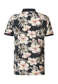 Camisa polo floral con fondo azul marino, grandes flores rosas y blancas, detalles verdes y un cuello de canalé negro.