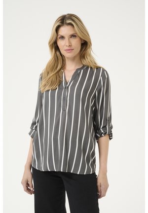 Blusa a righe grigia con colletto, chiusura a bottoni e maniche arrotolate. Realizzata in tessuto leggero con una texture liscia.