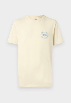 Camiseta de manga corta de color beige claro con cuello redondo y un pequeño logo azul de Rip Curl Surf Co. en el pecho izquierdo.