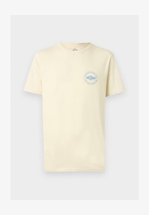 Νέος άνδρας με την πλάτη στραμμένη φορώντας ένα μπεζ T-shirt με μπλε λογότυπο «Rip Curl Surf Co Established 69» τυπωμένο στην πλάτη.