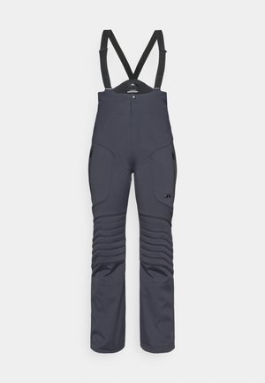 Pantaloni da sci grigio scuro con bretelle nere regolabili, tasche laterali con zip e imbottitura texturizzata lungo le cosce per un'isolamento migliorato.