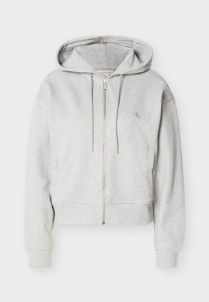 Világosszürke cipzáras kapucnis pulóver húzózsinórokkal, első zsebekkel, bordázott mandzsettákkal és kis "cK" logóval a bal mellrészen.