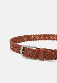 Ceinture en cuir tressé brun avec une boucle en métal argenté. Présente un design texturé avec des espaces entre les tresses pour plus de flexibilité.