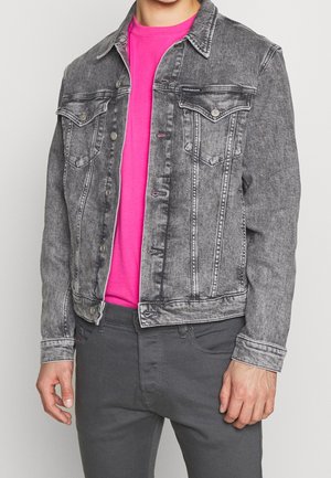 Veste en denim gris au design classique, avec des poches avant et des boutons-pression, associée à un t-shirt rose vif en dessous.