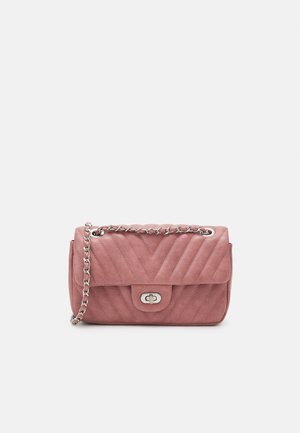 Bolso bandolera acolchado rosa con asa de cadena plateada y cierre de giro plateado sobre un fondo blanco liso.