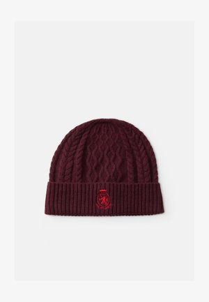 Gebreide beanie in bordeaux met kabelpatroon. Voorzien van een ribgebreide rand en een rood geborduurd logo. Zachte textuur en ronde vorm.
