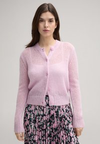Hellrosa gestrickte Strickjacke mit Rundhalsausschnitt, Knopfverschlüssen und geripptem Saum. Mit einem transparenten, strukturierten Stoffdesign.