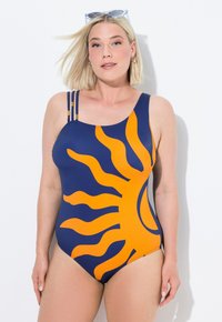 Eén piece zwempak in marineblauw met een grote oranje zonafbeelding. Beschikt over twee tankbandjes met gouden accenten. Gladde textuur, rekbaar materiaal.